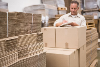 Man bij stapel gevouwen dozen op maat